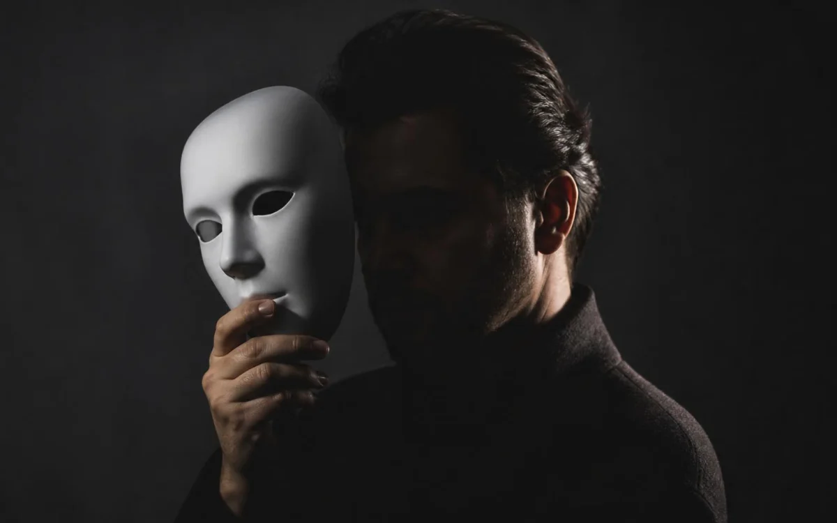 Mężczyzna trzymający białą maskę Mężczyzna trzymający białą maskę