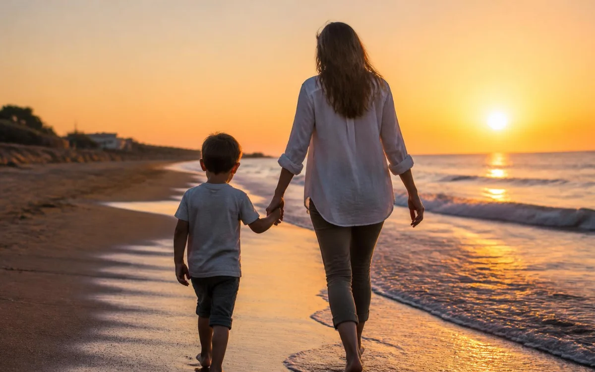 Mama z synem spacerują po plaży o zachodzie słońca Mama z synem spacerują po plaży o zachodzie słońca